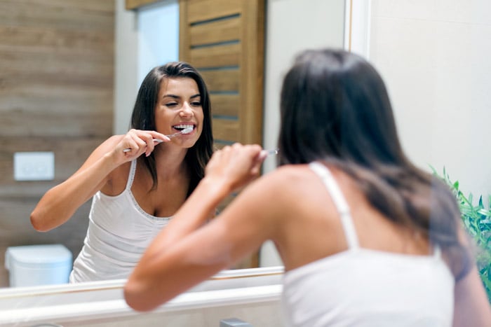 mujer-lavandose-los-dientes-como-prevenir-caries-blog-salud-humana